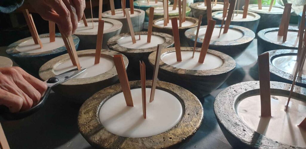 cutting the wooden wicks of stone concrete candles
