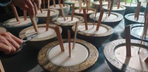 cutting the wooden wicks of stone concrete candles